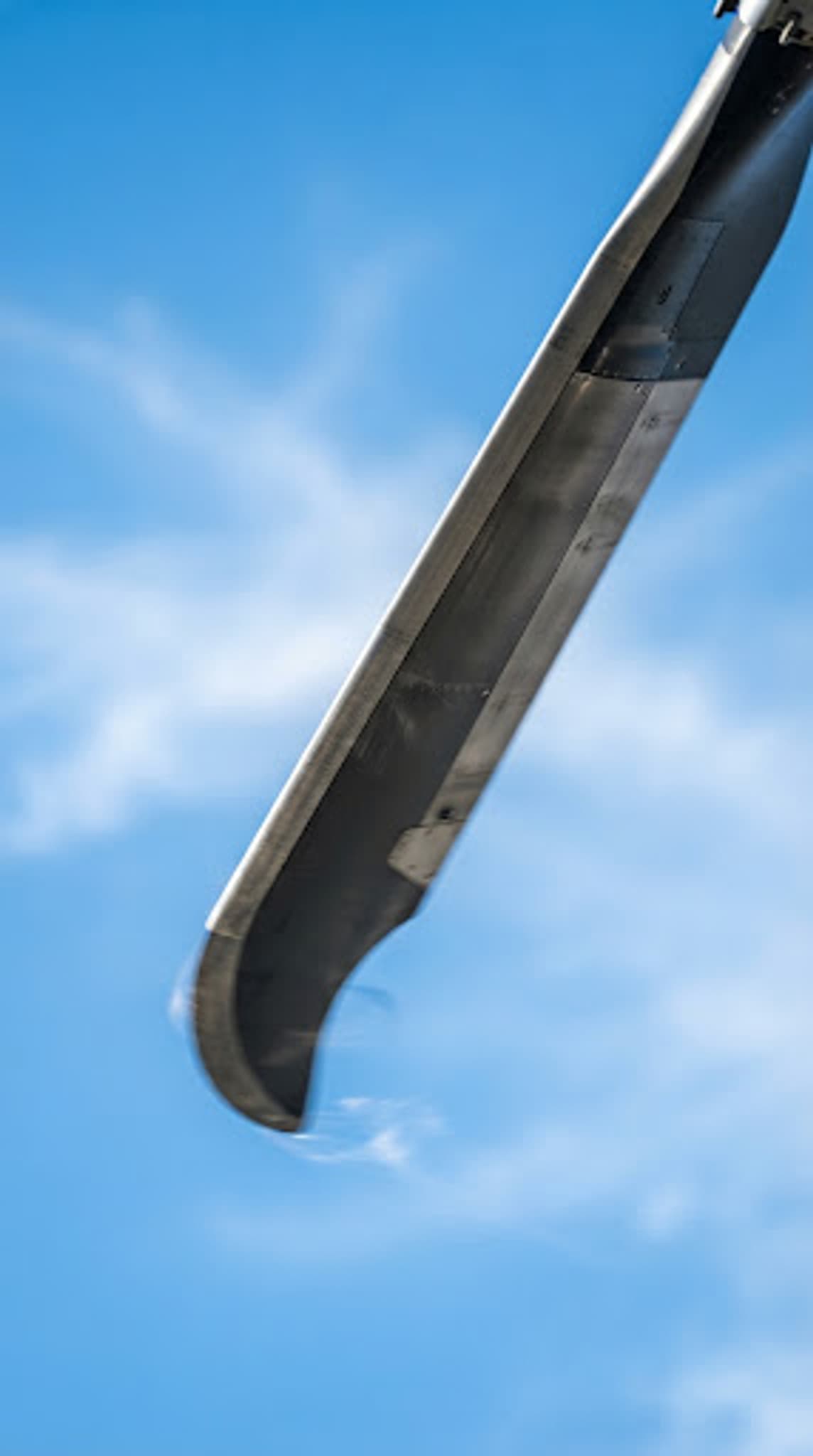 Close view of a helicopter rotor against a blue sky